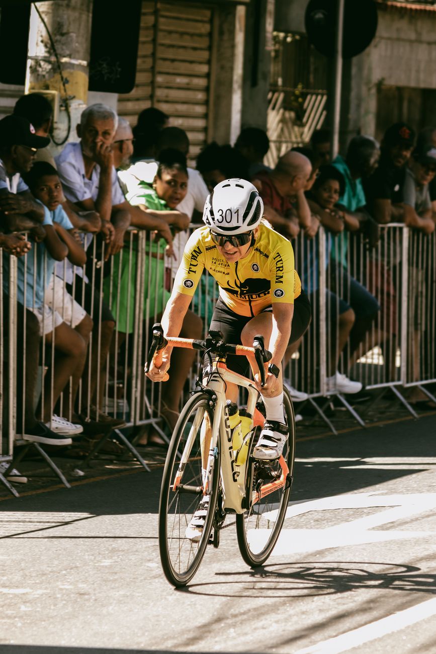 a cyclist is riding down a street in front of a crowd