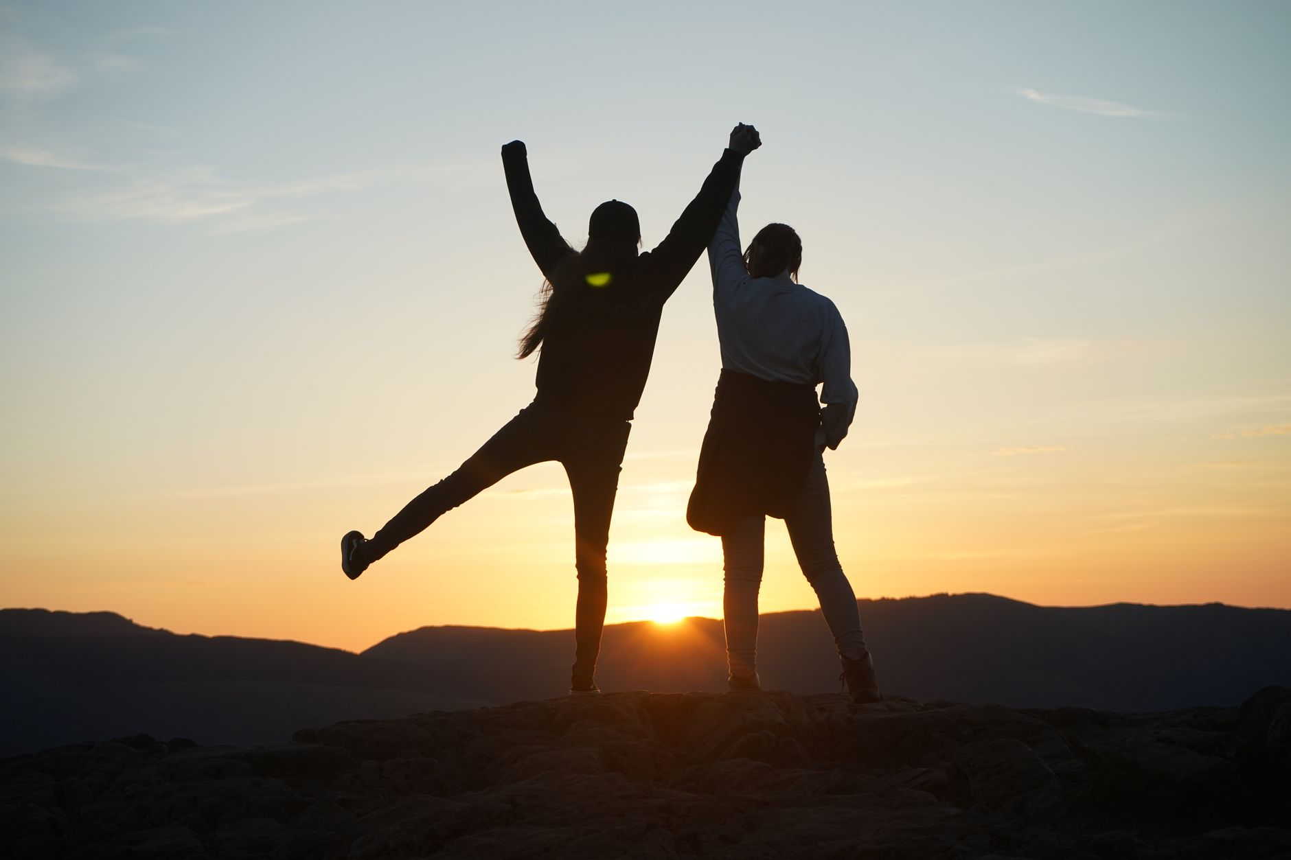 joyful silhouette of couple hiking at sunset